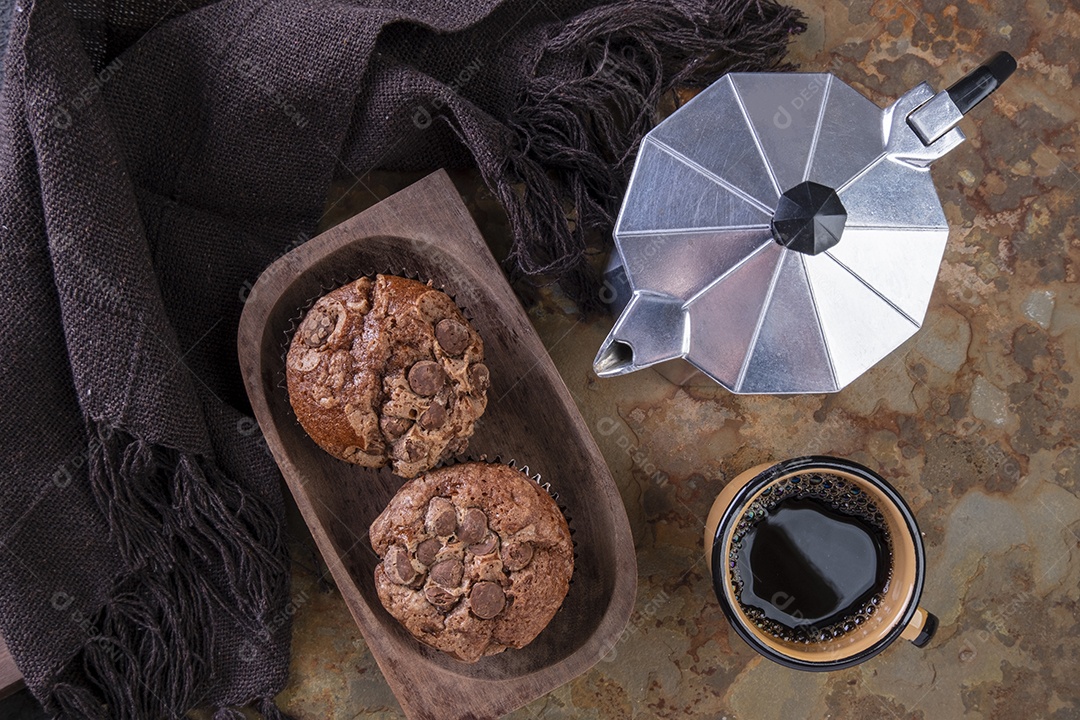 Deliciosos muffins de chocolate, uma caneca de café e uma tradicional cafeteira italiana.