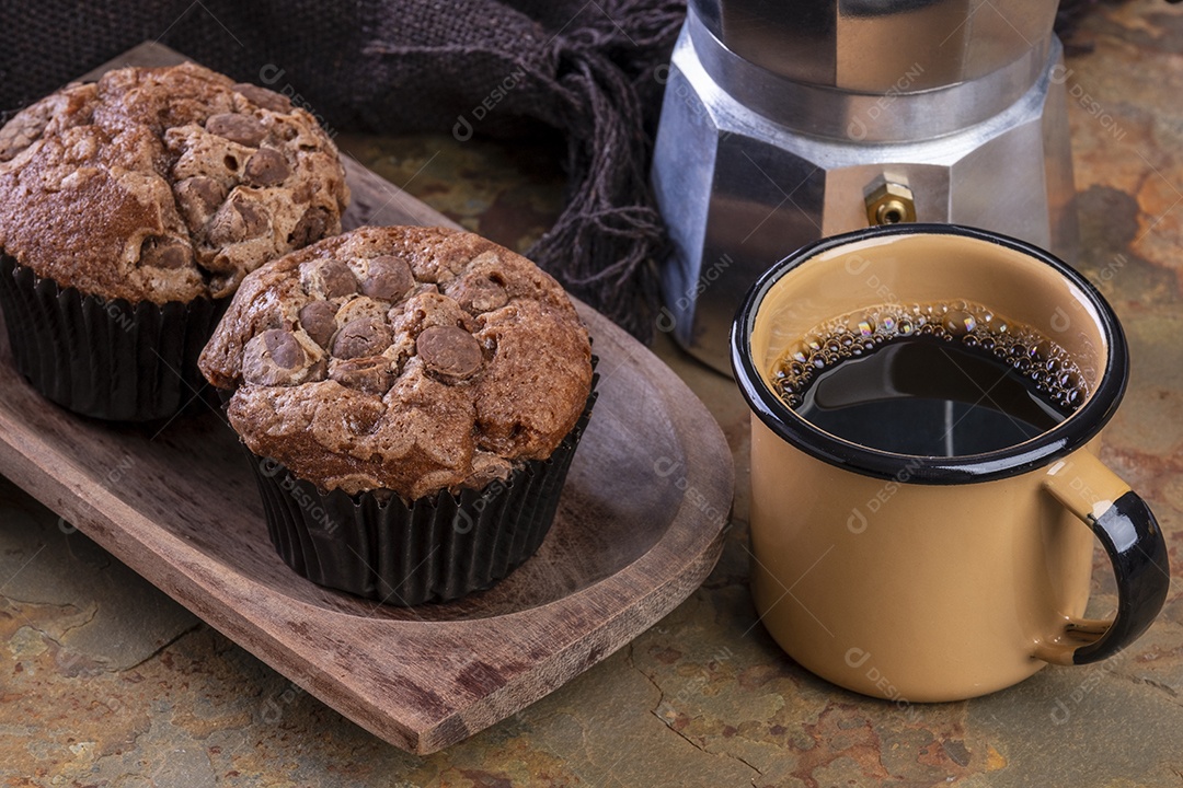 Deliciosos muffins de chocolate, uma caneca de café e uma tradicional cafeteira italiana.