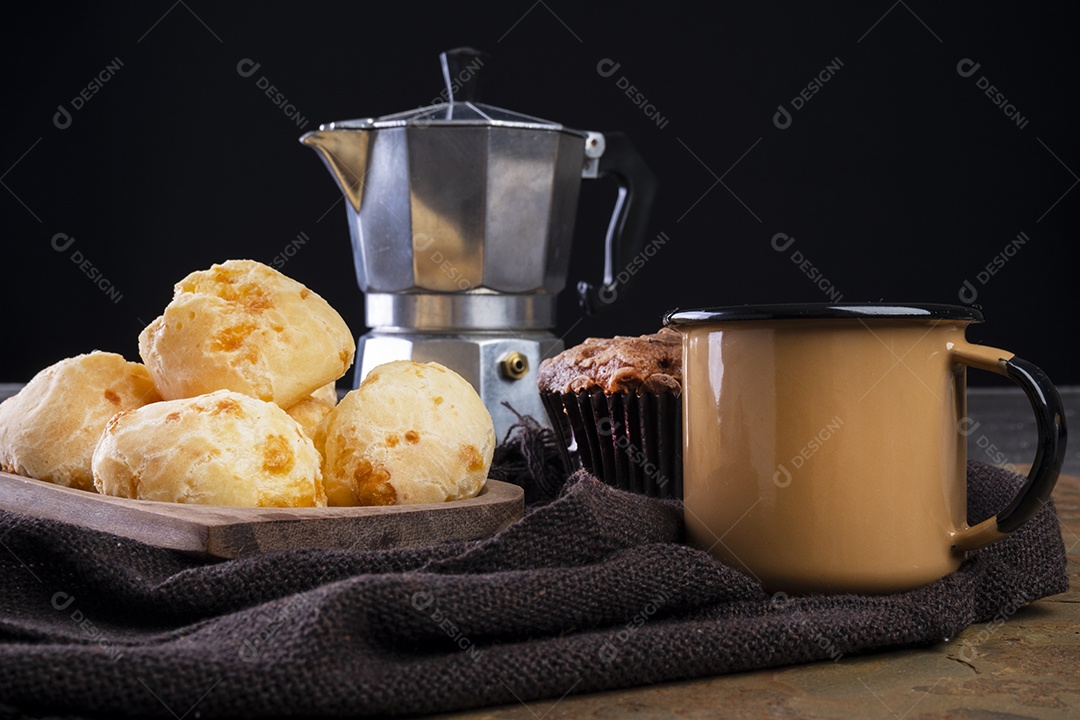 Deliciosos pães de queijo e uma caneca de café em fundo escuro