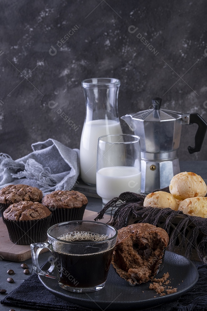Uma xícara de café, muffins de chocolate, pães de queijo e leite