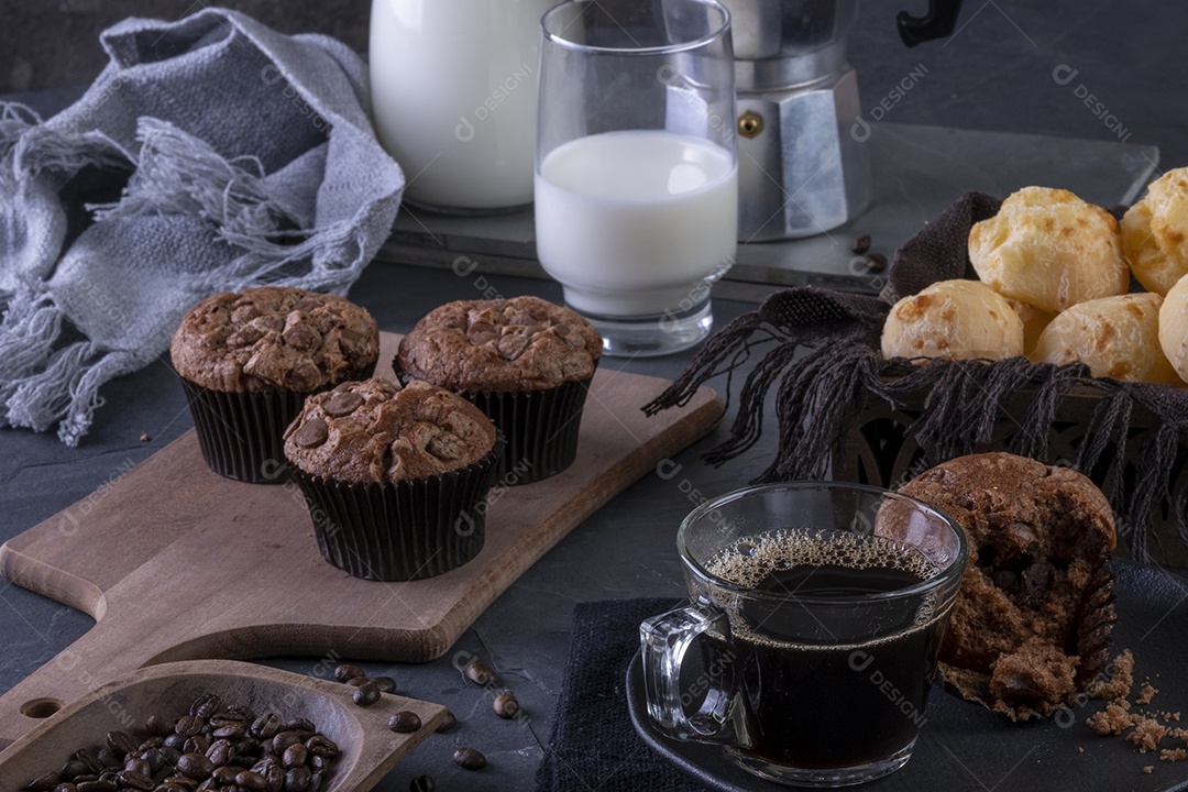 Uma xícara de café, muffins de chocolate, pães de queijo e leite