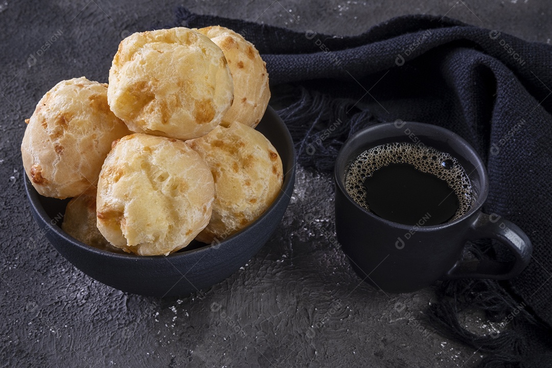 Deliciosos pães de queijo e uma caneca de café em fundo escuro