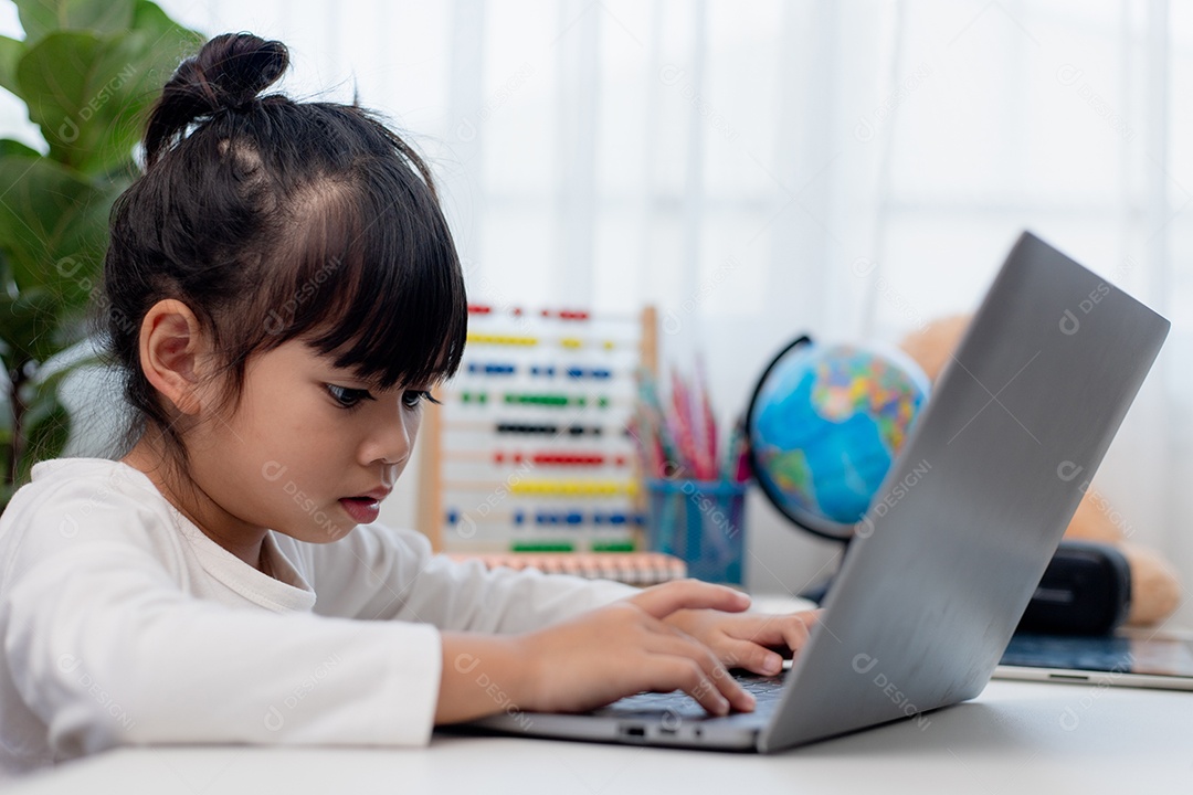 Aluna asiática fazendo sua lição de casa com o laptop em casa. As crianças usam aparelhos para estudar. Educação e ensino a distância para crianças. Educação domiciliar durante a quarentena. Ficar em casa