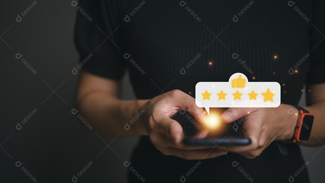 Pressionando a mão na tela do smartphone com o ícone de feedback de classificação de cinco estrelas em ouro e pressione o nível de classificação excelente para dar o melhor ponto de pontuação para revisar o serviço, o conceito de negócios