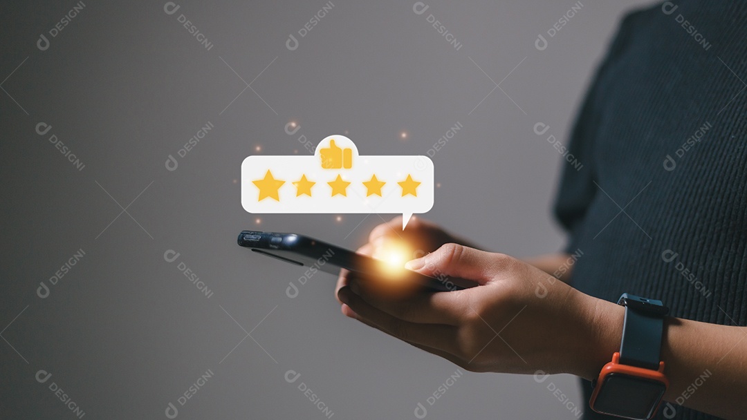 Pressionando a mão na tela do smartphone com o ícone de feedback de classificação de cinco estrelas em ouro e pressione o nível de classificação excelente para dar o melhor ponto de pontuação para revisar o serviço, o conceito de negócios