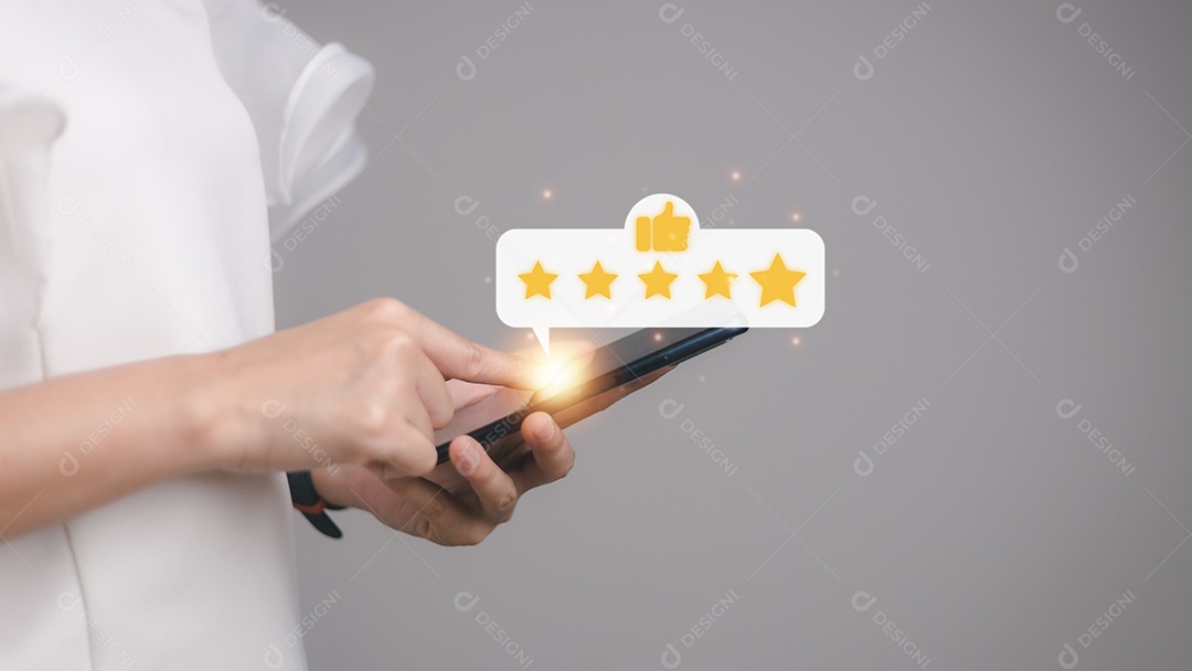 Pressionando a mão na tela do smartphone com o ícone de feedback de classificação de cinco estrelas em ouro e pressione o nível de classificação excelente para dar o melhor ponto de pontuação para revisar o serviço, o conceito de negócios