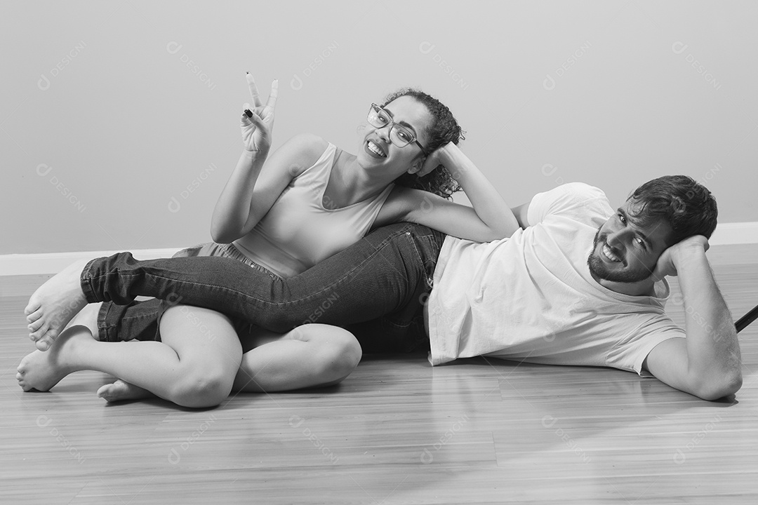 Casal de jovens homem e mulher feliz e deitado sobre chão
