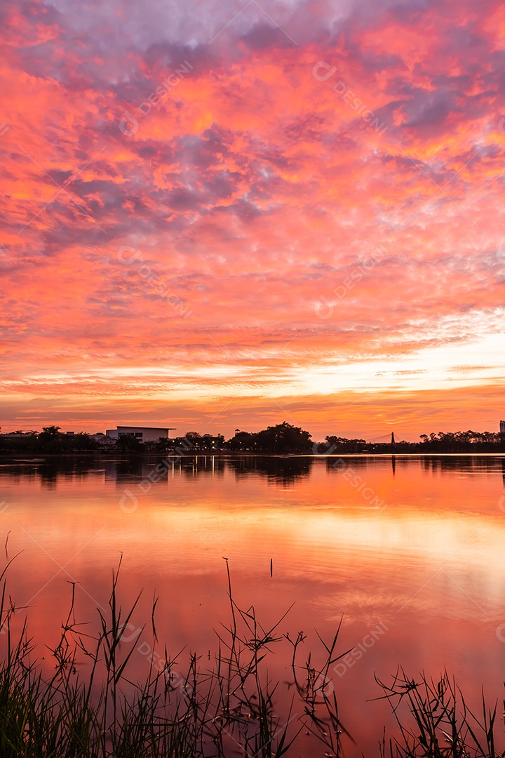 O pôr do sol quase cai do céu no horizonte refletido na água
