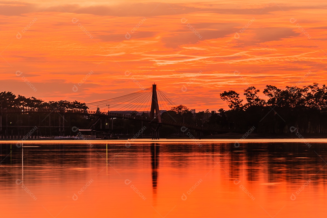 O pôr do sol quase cai do céu no horizonte refletido na água