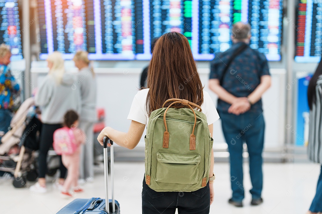 Jovem mulher com mochila olhando as informações de tempo de voo