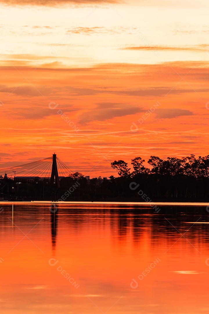 O pôr do sol quase cai do céu no horizonte refletido na água