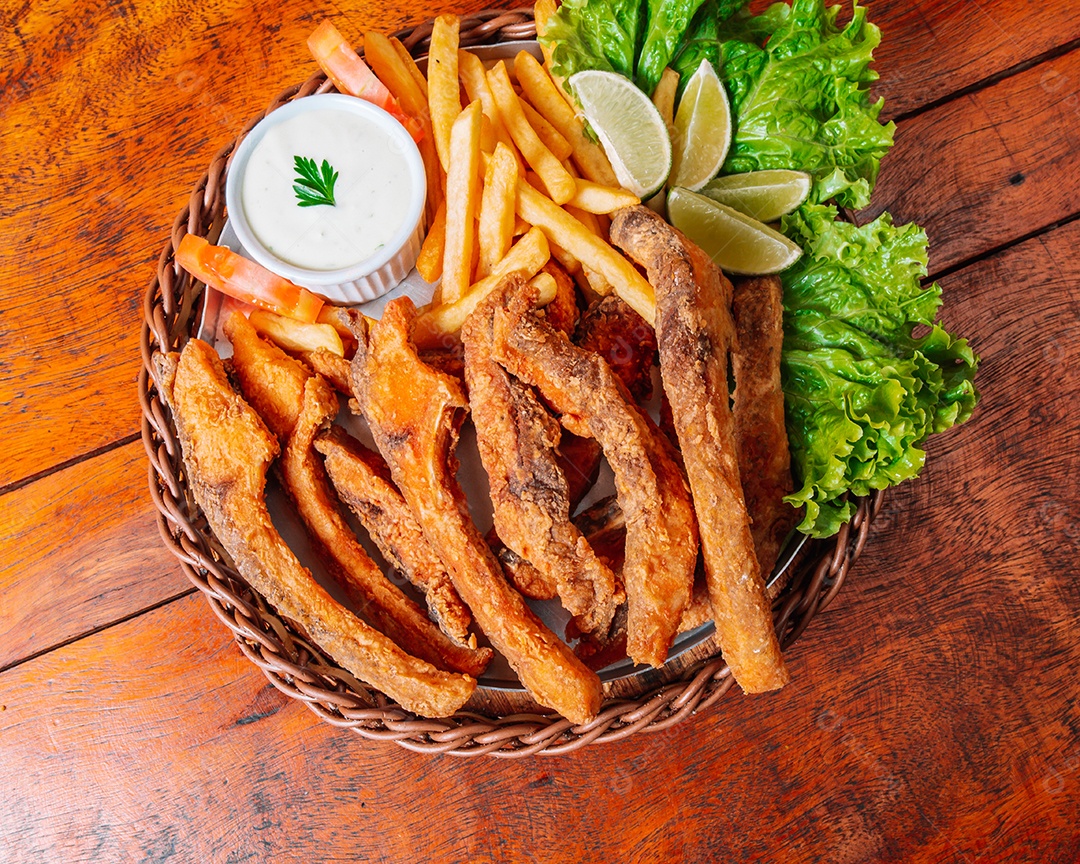 Porção de fritas com batata frita sobre uma mesa de madeira