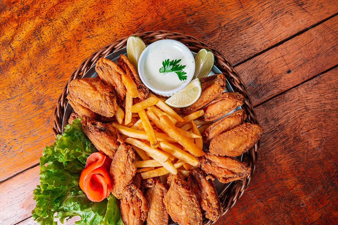 Porção de fritas com batata frita sobre uma mesa de madeira