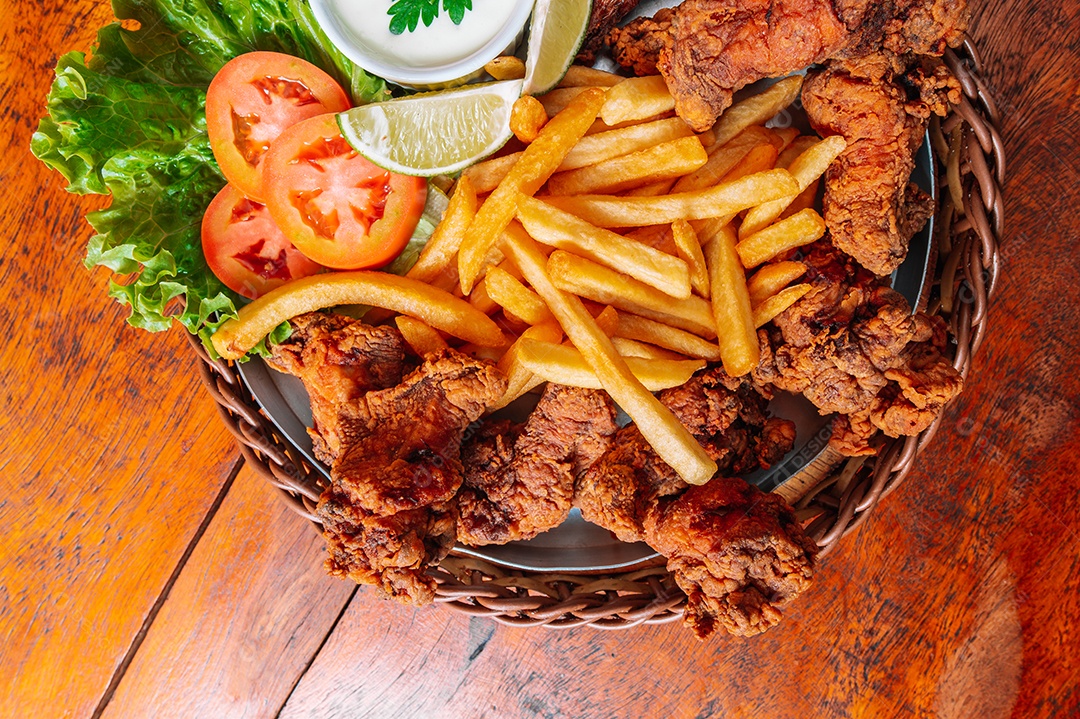 Porção de fritas com batata frita sobre uma mesa de madeira