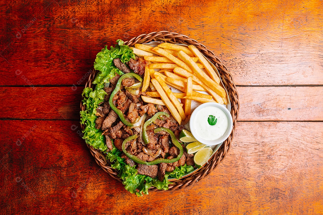 Porção de fritas com batata frita sobre uma mesa de madeira