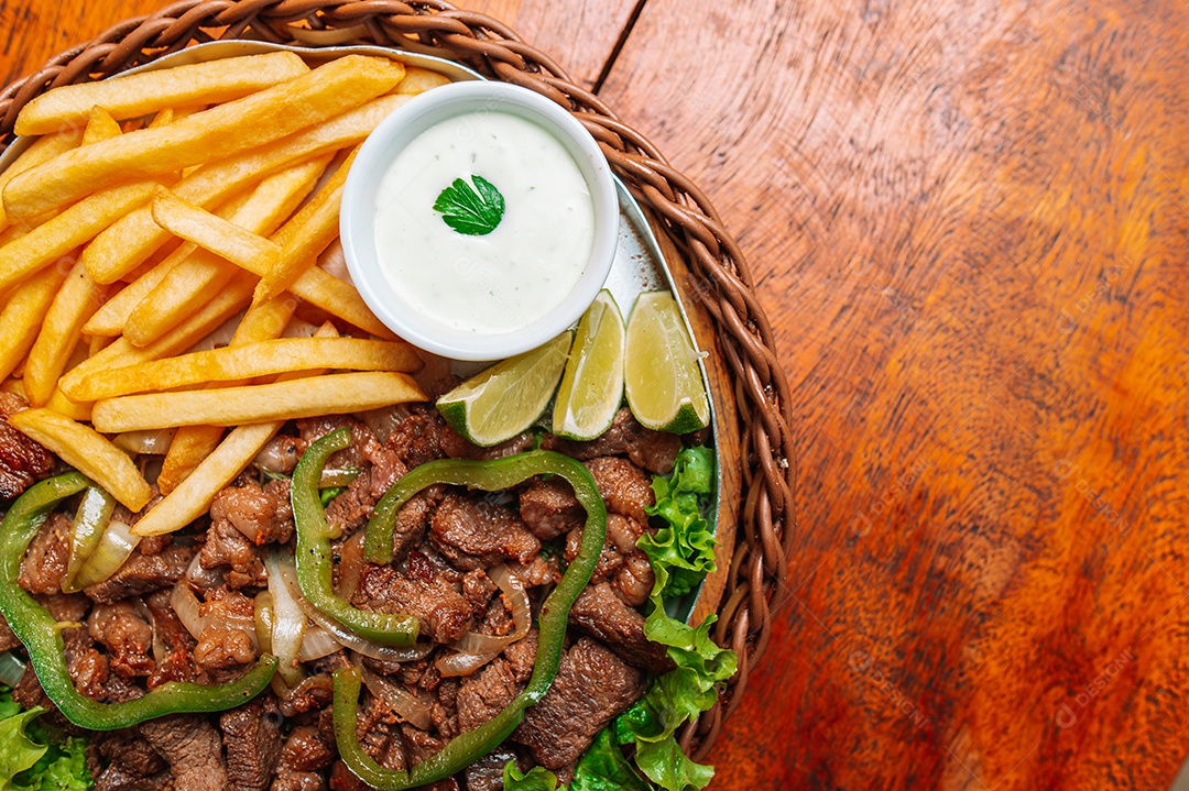 Porção de fritas com batata frita sobre uma mesa de madeira