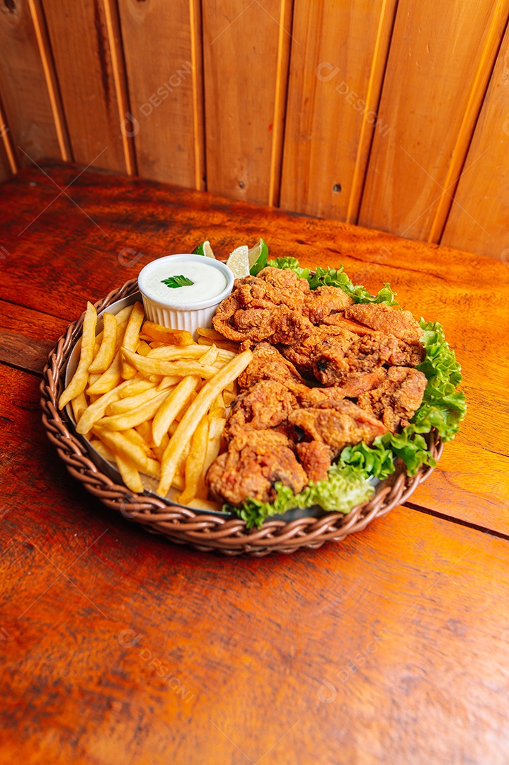 Porção de fritas com batata frita sobre uma mesa de madeira