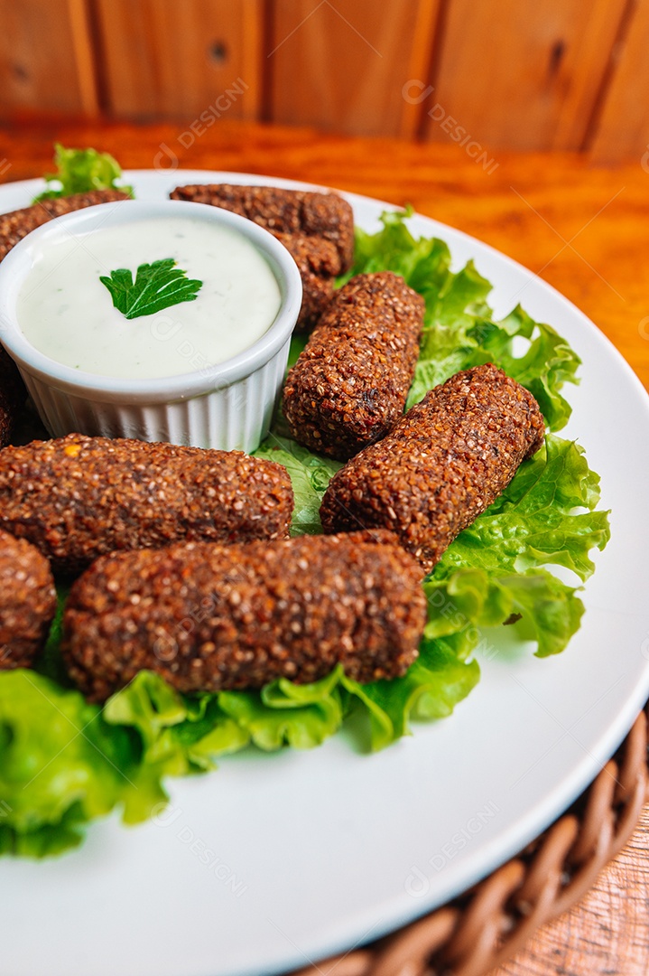 Porção de fritas com carne frita sobre uma mesa de madeira