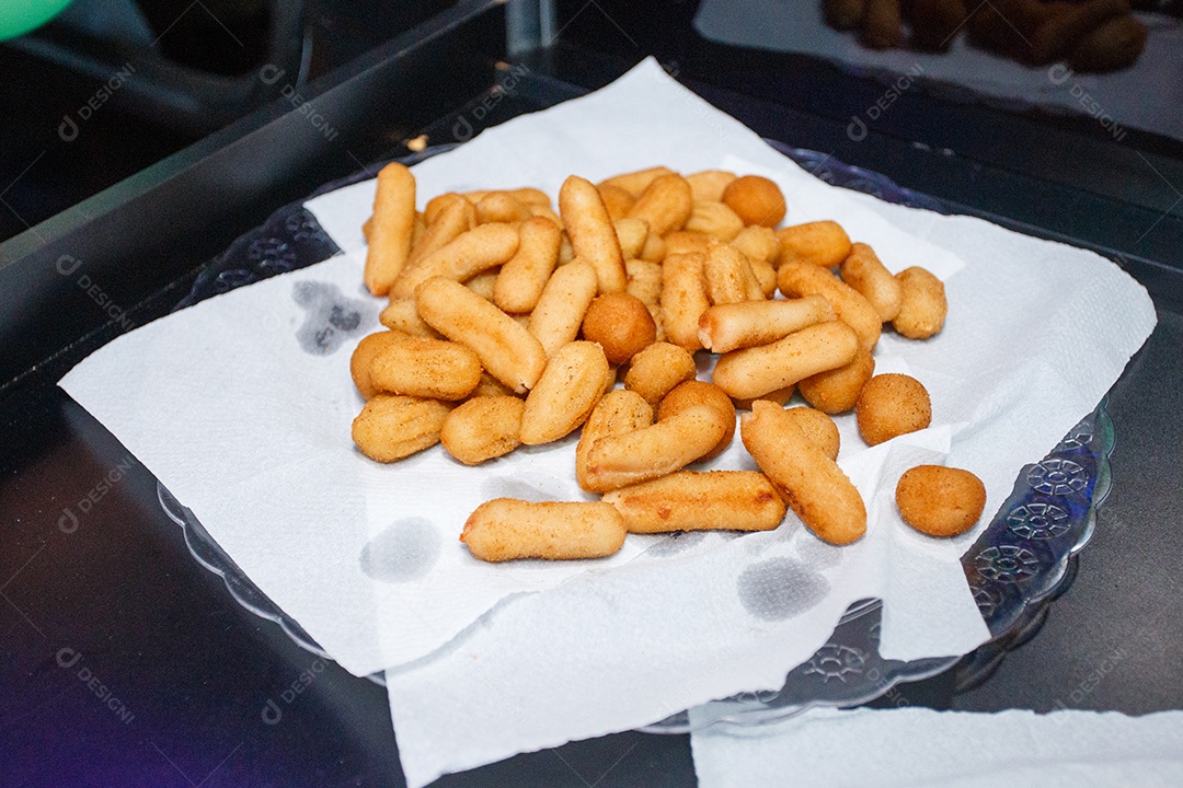 Petiscos típicos de festa brasileira em mesa preta com guardanapo branco no Rio de Janeiro.