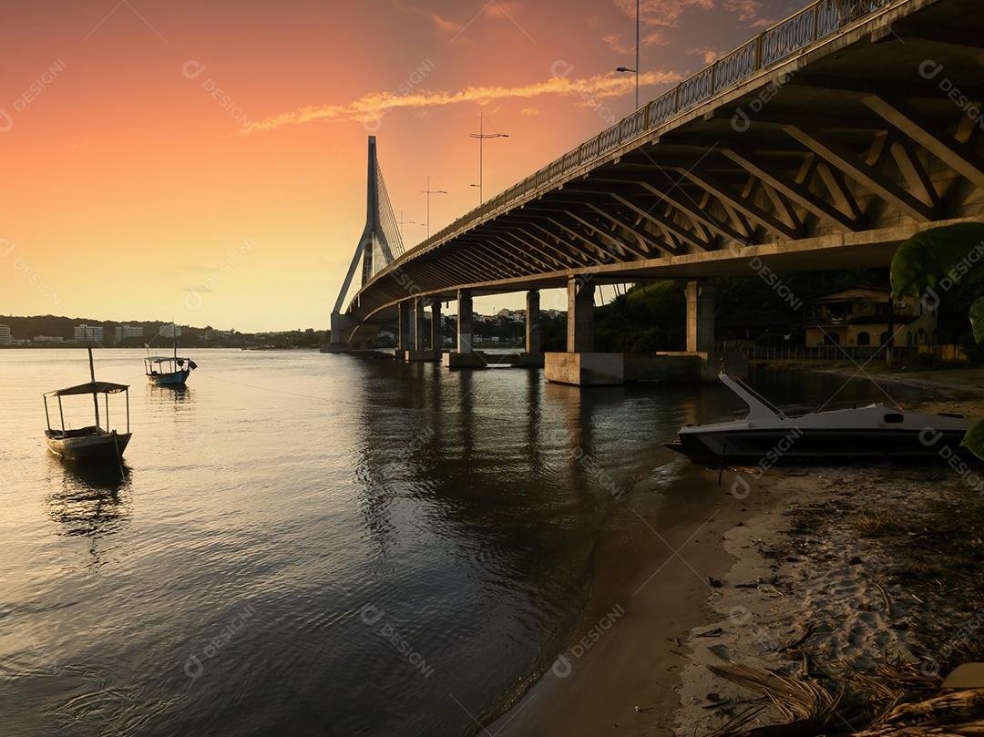 Pôr do sol com a ponte estaiada Jorge Amado ao fundo em Ilhéus, Bahia, Brasil.