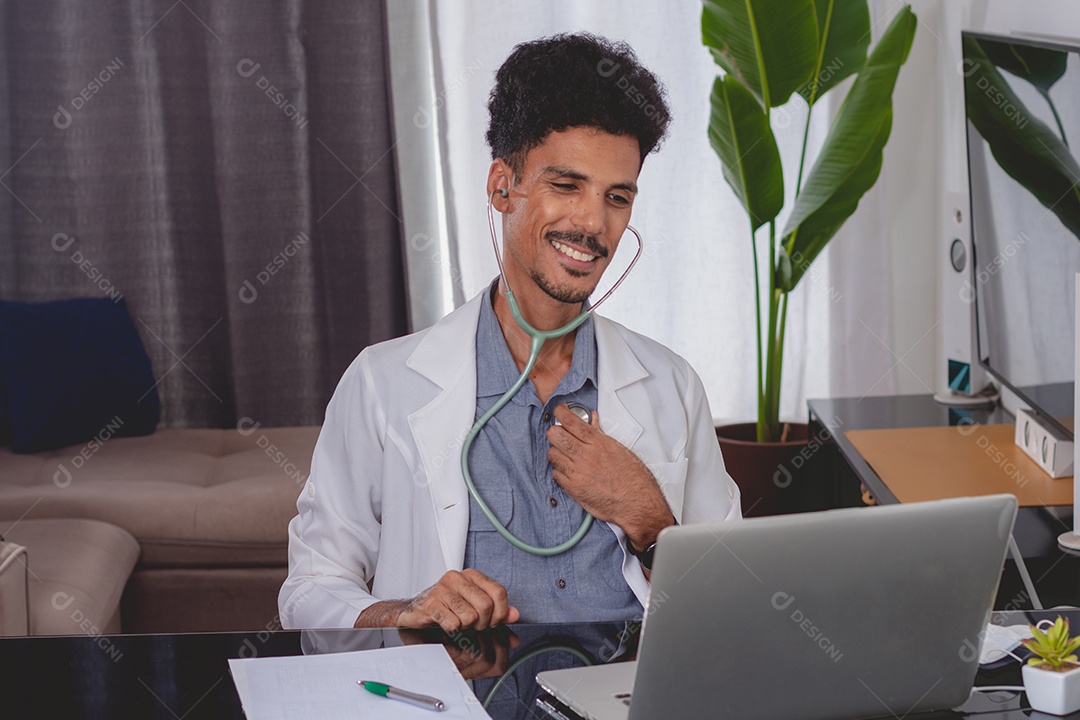 Jovem fazendo home office durante o dia na mesa com laptop, tablet e celular