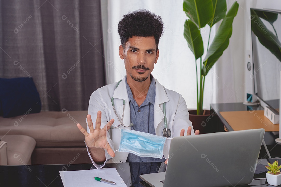 Jovem fazendo home office durante o dia na mesa com laptop, tablet e celular