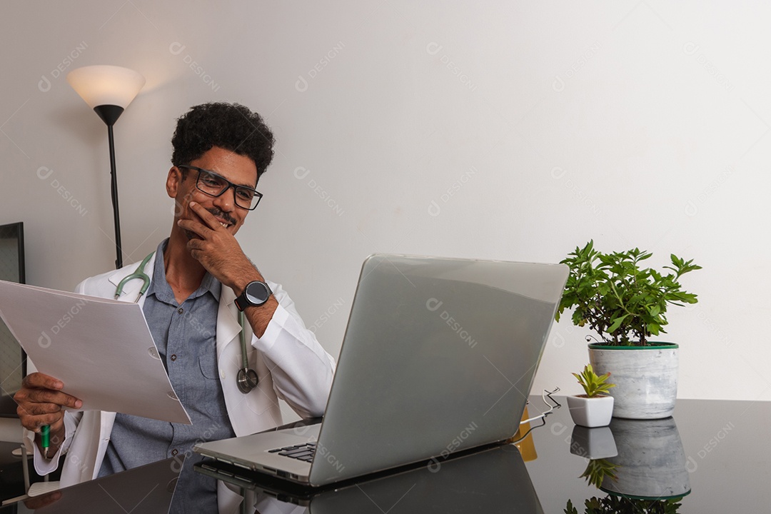 Jovem fazendo home office durante o dia na mesa com laptop, tablet e celular