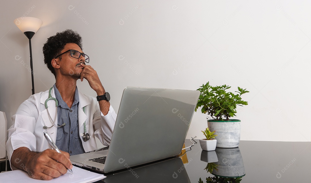 Jovem fazendo home office durante o dia na mesa com laptop, tablet e celular