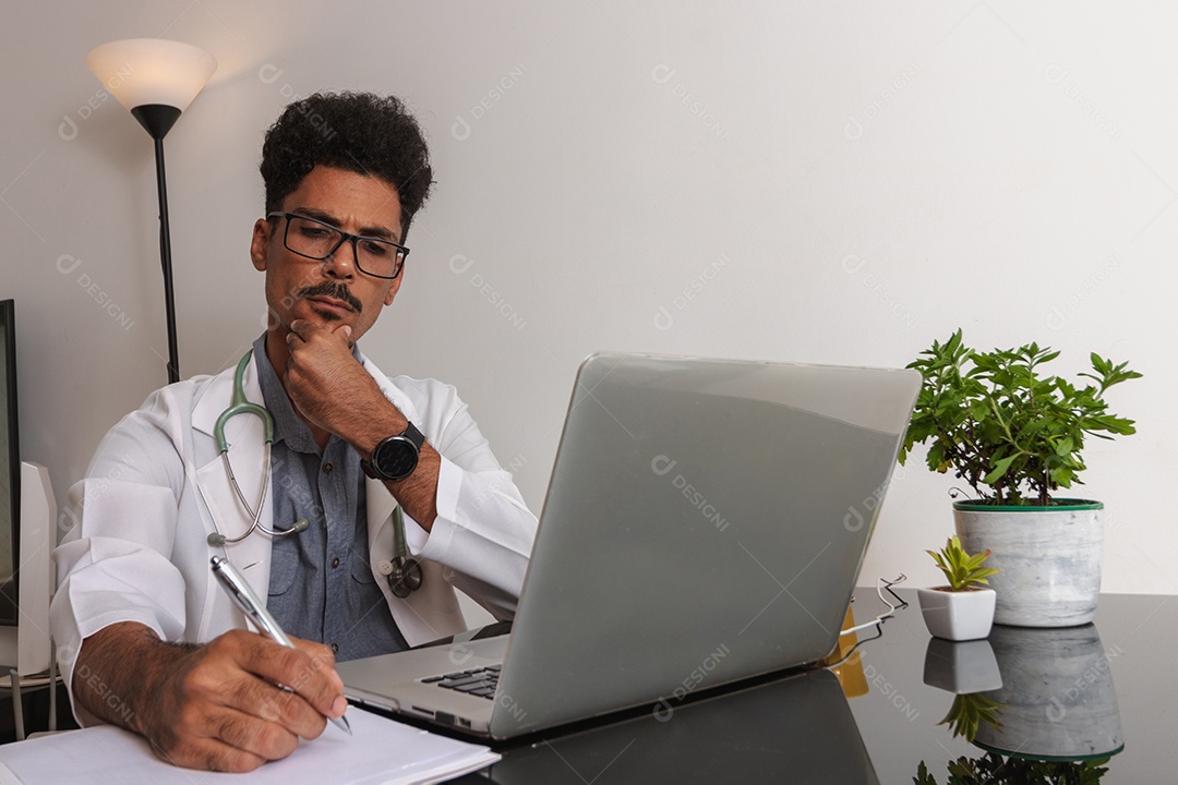 Jovem fazendo home office durante o dia na mesa com laptop, tablet e celular