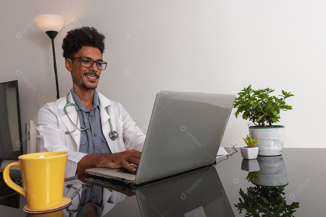 Jovem fazendo home office durante o dia na mesa com laptop, tablet e celular