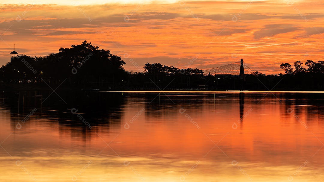 O pôr do sol quase cai do céu no horizonte refletido na água