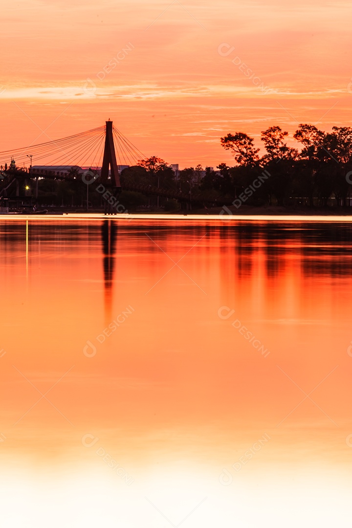 O pôr do sol quase cai do céu no horizonte refletido na água