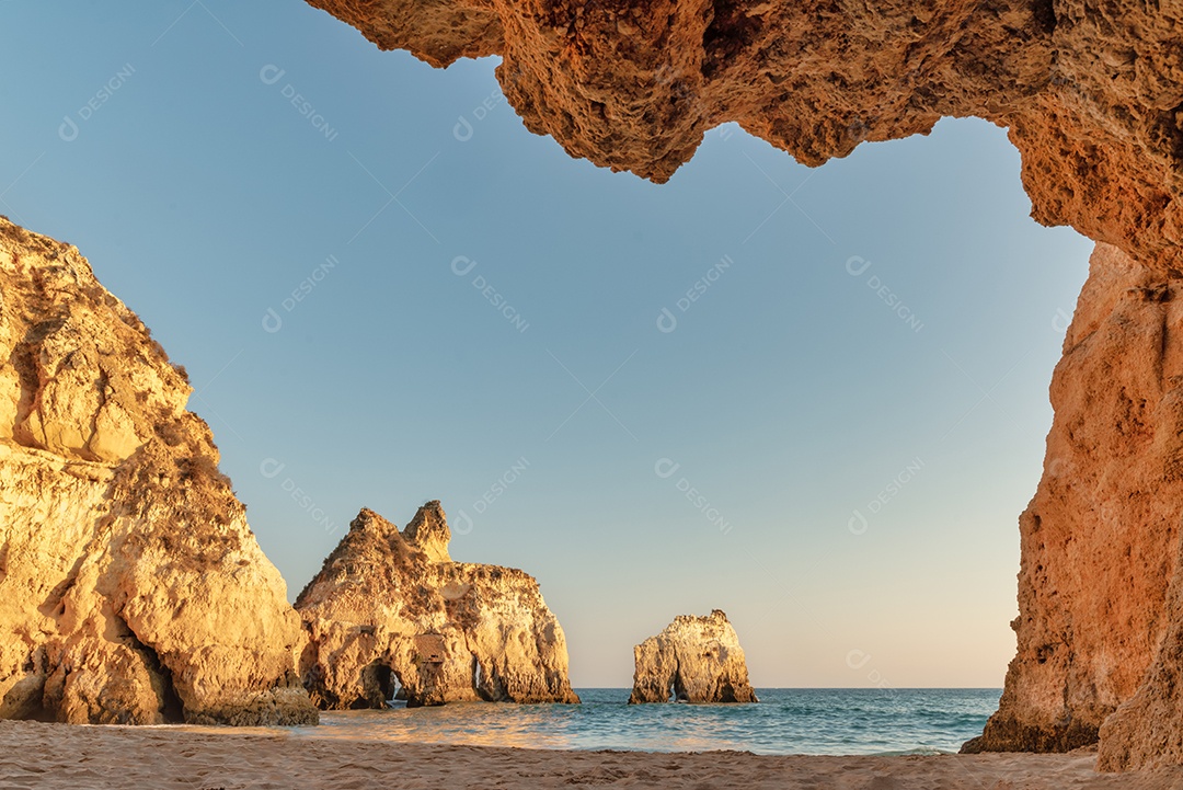 Algarve, Portugal - Vista da praia e de Alvor a partir de uma gruta - Falésias iluminadas pelo pôr do sol