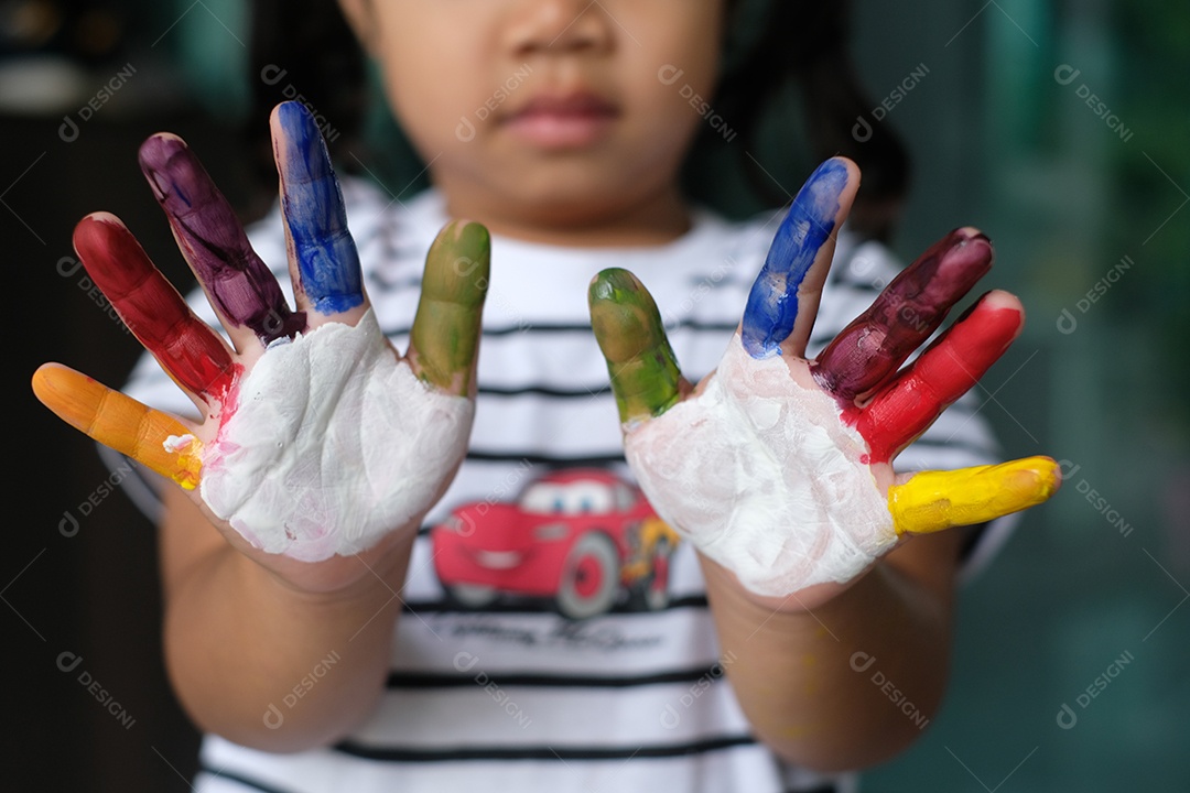 Linda menina criança com as mãos pintadas