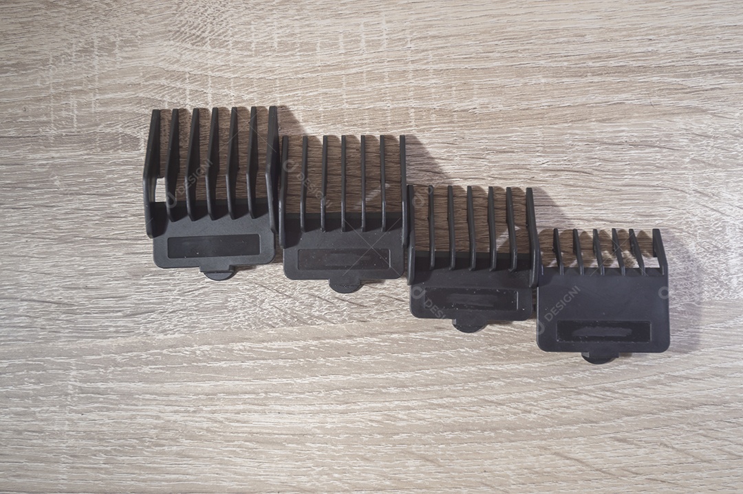 Máquina de corte de cabelo e acessórios de cabelo com fundo de madeira branca, pentes de máquina de corte de cabelo, conceito de cabeleireiro.