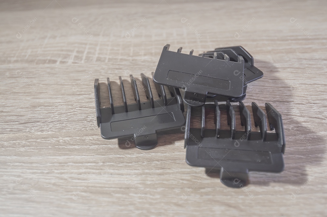 Máquina de corte de cabelo e acessórios de cabelo com fundo de madeira branca, pentes de máquina de corte de cabelo, conceito de cabeleireiro.