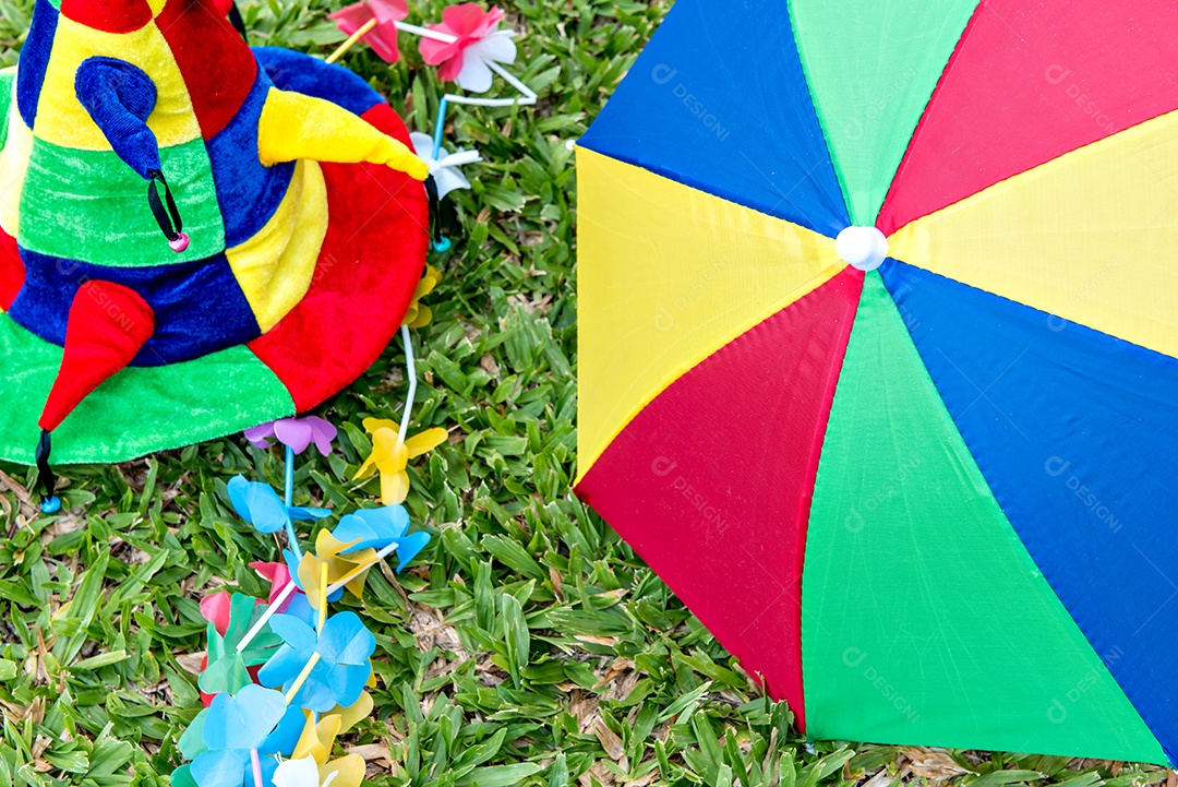 Chapéu de carnaval e guarda-chuva colorido deitado na grama