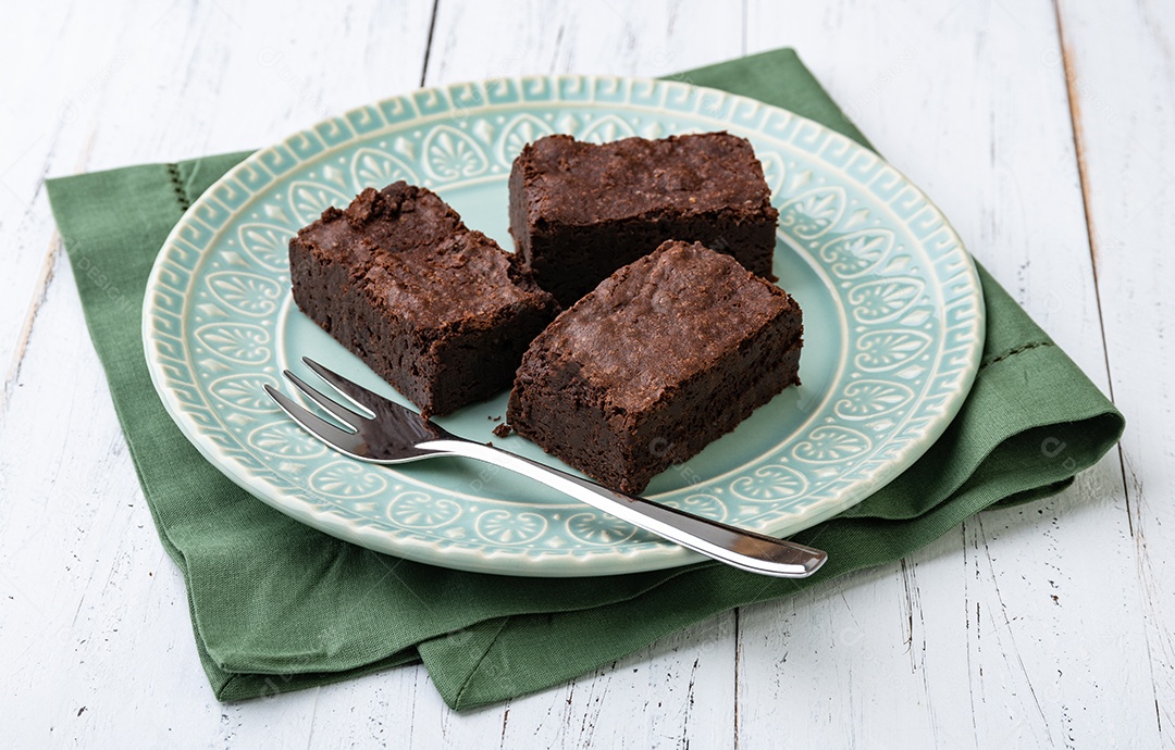 Pedaços de brownies sobre mesa de madeira branca