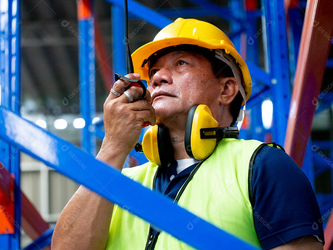Homem falando em um rádio dando instruções ao demais trabalhadores