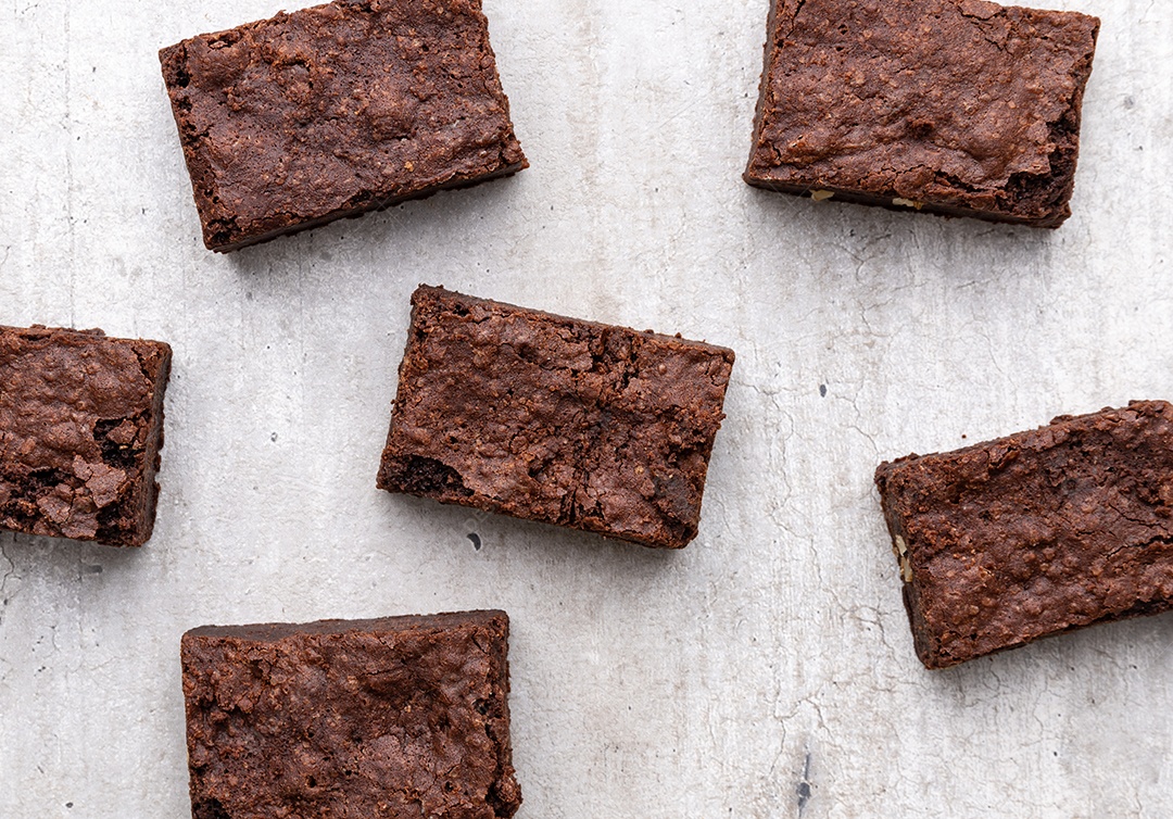 Pedaços de brownies sobre mesa de madeira branca