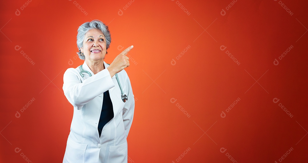 Médica brasileira madura ou mulher veterinária com estetoscópio isolado em fundo laranja