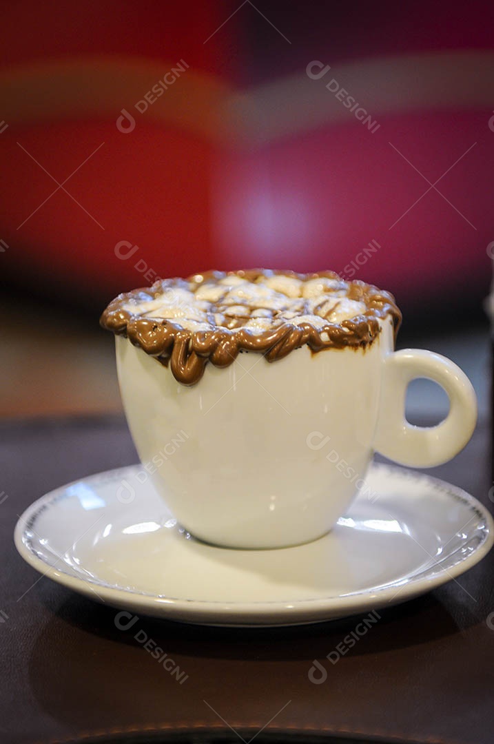 Café Mocha em uma mesa de café  e fundo desfocado de tons vermelhos.