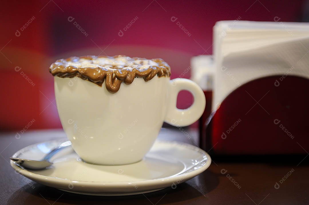 Café Mocha em uma mesa de café e fundo desfocado de tons vermelhos.