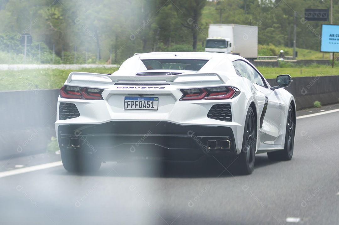 Carro de luxo Corvete passando em uma rodovia.