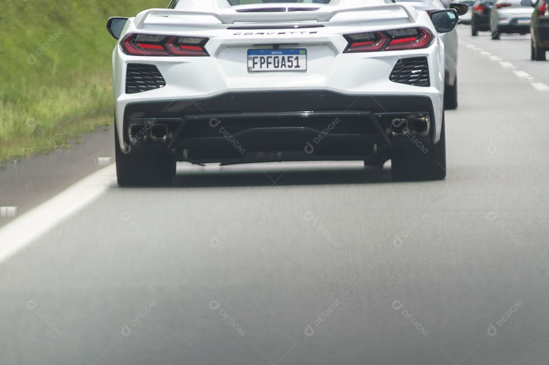 Carro de luxo Corvete passando em uma rodovia.
