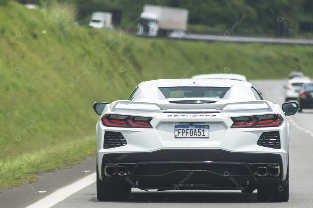 Carro de luxo Corvete passando em uma rodovia.