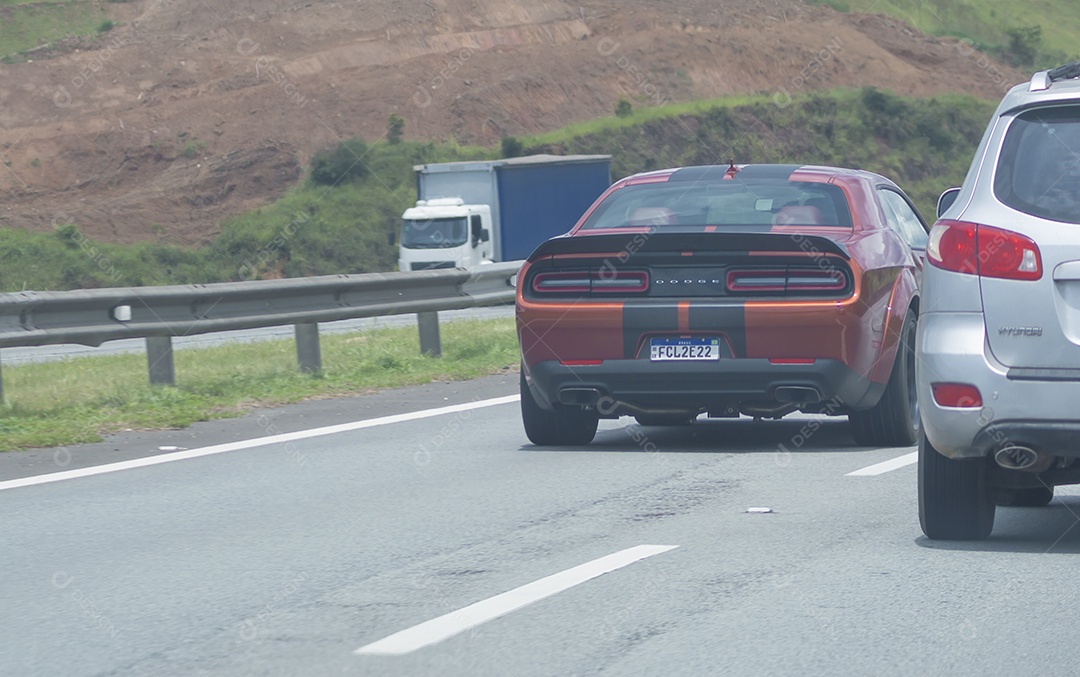 Carro de luxo da marca dodge passando em uma rodovia.