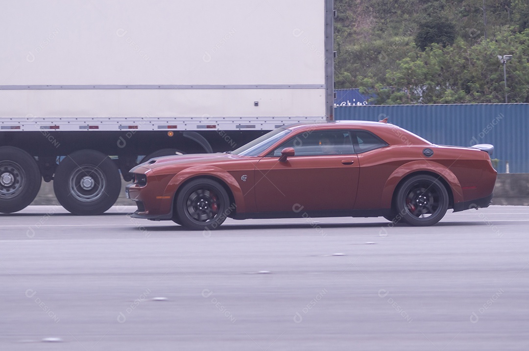 Carro de luxo da marca dodge passando em uma rodovia.