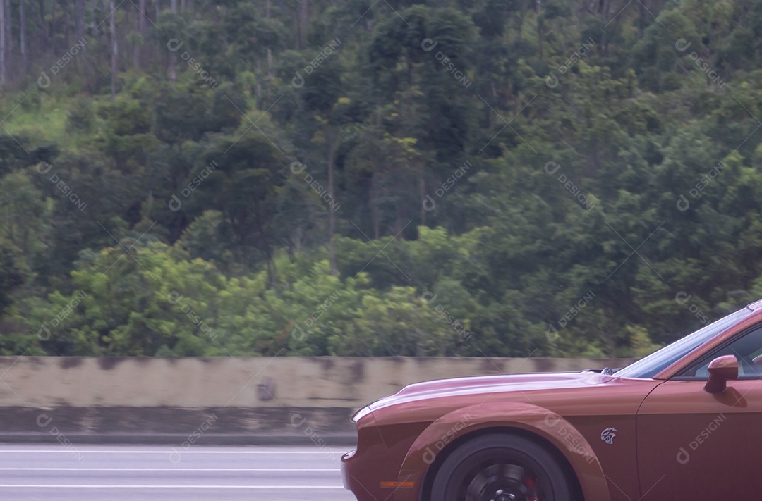 Carro de luxo da marca dodge passando em uma rodovia.
