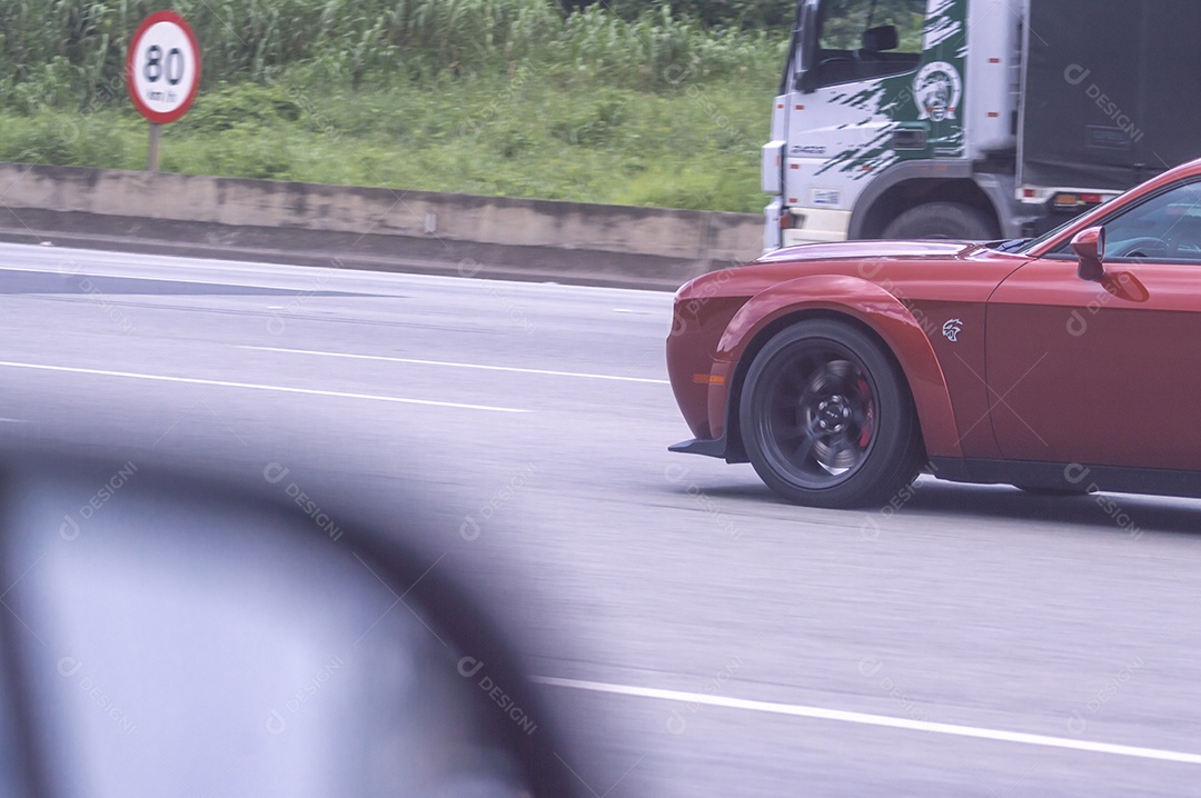 Carro de luxo Corvete passando em uma rodovia.